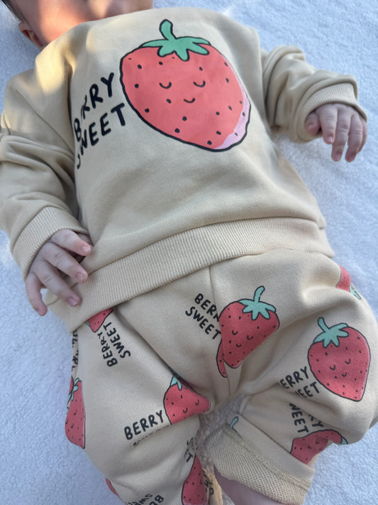 Baby wearing the Berry Sweet kids matching set with cream sweatshirt and strawberry print pants by Step By Step Co.