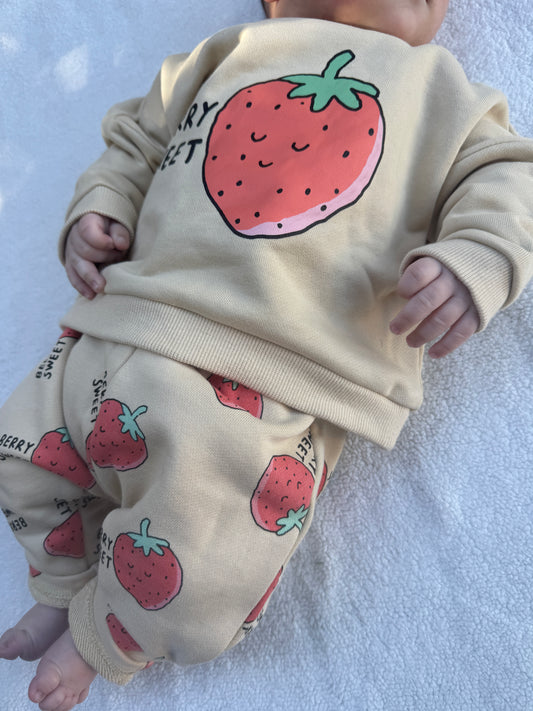 Baby wearing the Berry Sweet kids matching set with cream sweatshirt and strawberry print pants by Step By Step Co.